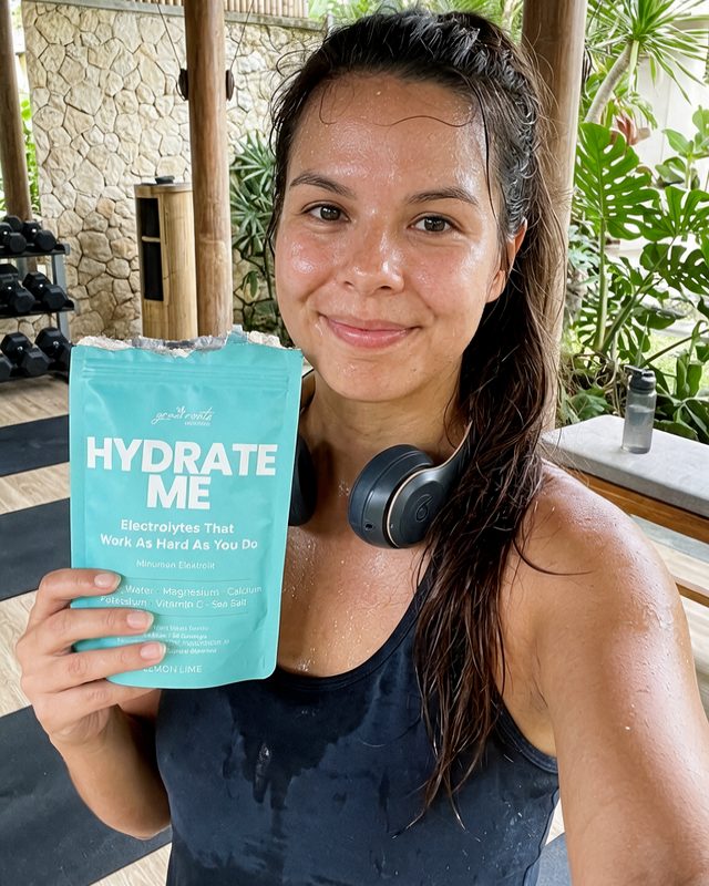 Phoebe at a gym holding a pouch of Hydrate Me