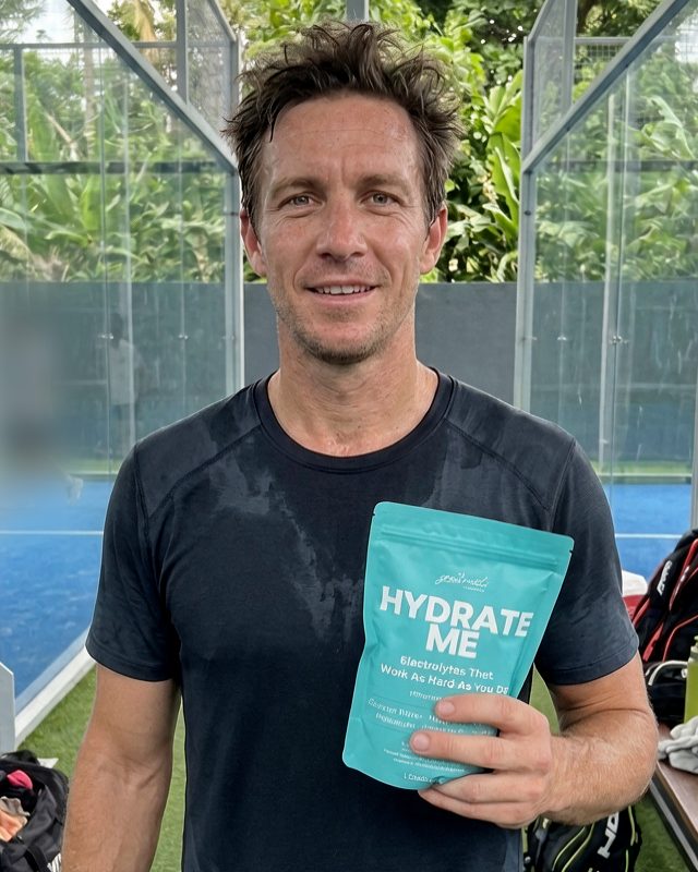 Gabriel on a padel court holding a pouch of Hydrate Me